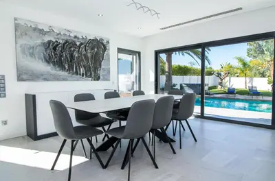 a dining room with a table and chairs and a pool at Villa Videira By Dalma Portuguesa - By Dalma Portuguesa in Albufeira