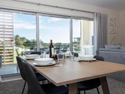 a dining room with a table with a bottle of wine at Green 2 Apartment by Stay ici Algarve Holiday Rental in Albufeira