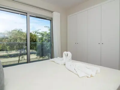 a bedroom with a white bed with a large window at Green 2 Apartment by Stay ici Algarve Holiday Rental in Albufeira