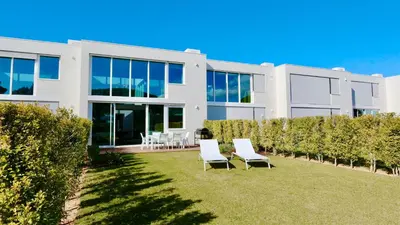 a white house with chairs in the yard at Vila Leonor - Clever Details , Central Vilamoura, Sleeps 6, luxury, walking distance in Vilamoura