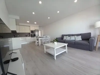 a living room with a couch and a table at T3 Alto Forte -Vista Mar,Ar Condicionado,Garagem in Quarteira