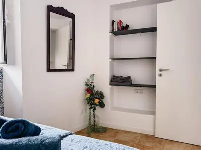 a bedroom with a bed and a mirror and a vase with flowers at Old Fisherman's Corner 5 - Centro Old Town Albufeira in Albufeira