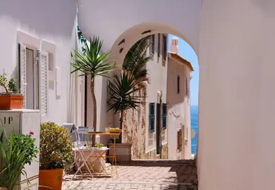 an archway in a building with a view of the ocean at Old Fisherman's Corner 5 - Centro Old Town Albufeira in Albufeira