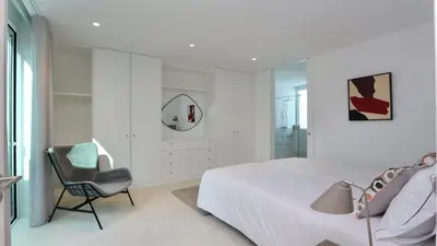 a bedroom with a bed and a chair and a mirror at Villa Emilia - Clever Details , Central Vilamoura, Sleeps 6, luxury, walking distance in Vilamoura