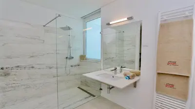 a bathroom with a sink and a glass shower at Villa Emilia - Clever Details , Central Vilamoura, Sleeps 6, luxury, walking distance in Vilamoura