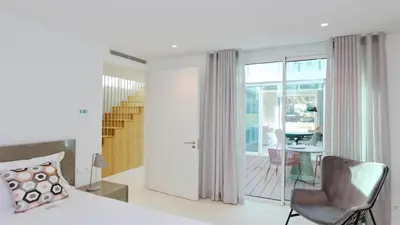 a bedroom with a bed and a chair and a table at Villa Emilia - Clever Details , Central Vilamoura, Sleeps 6, luxury, walking distance in Vilamoura