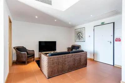a living room with a couch and a table at Superbe appartement spacieux avec terrasse vue piscine in Vilamoura