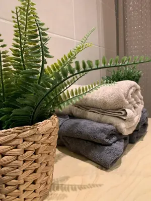a basket of towels and a plant on a counter at ALDEIA DAS AÇOTEIAS VILLAGEs in Albufeira