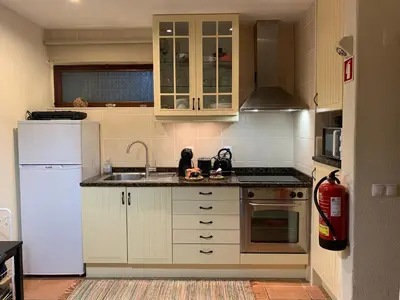 a kitchen with a white refrigerator and a sink at ALDEIA DAS AÇOTEIAS VILLAGEs in Albufeira