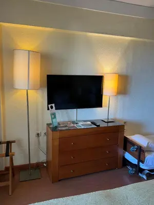 a room with two lamps and a television on a dresser at Semanas 30 e 24 Vila Galé Cerro Alagoa in Albufeira