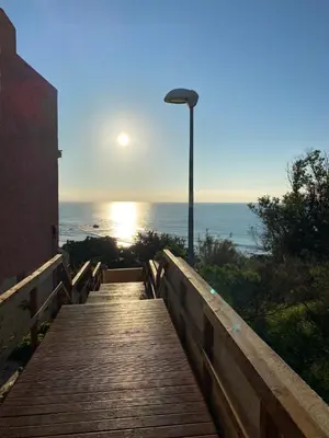 a wooden boardwalk leading to the ocean with a street light at Appartement ALGARDEN Olhos d'Agua in Olhos de Água