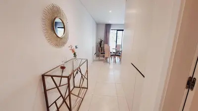 a hallway with a glass table and a mirror at Apartamento Meerblick in Quarteira