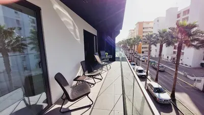 a balcony with chairs and a view of a street at Apartamento Meerblick in Quarteira