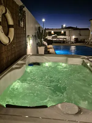a jacuzzi tub with green liquid in it next to a pool at Villa O Canto da Parra - Hot Jacuzzi - Swimming Pool - WIFI - BY BEDZY in Galé