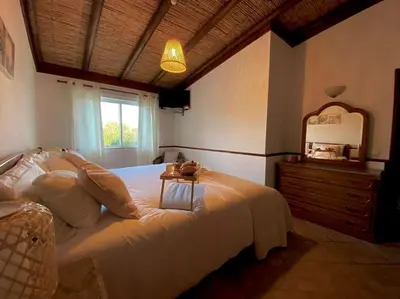 a bedroom with a white bed with a table on it at Palma's Place Casanova Villa #WIFI#HEATEDPOOL#RELAX in Faro