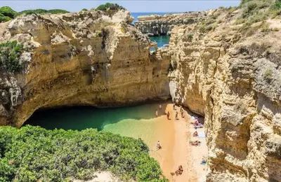 a group of people on a beach in a cave at Appartement Standing au coeur d'Albufeira in Albufeira