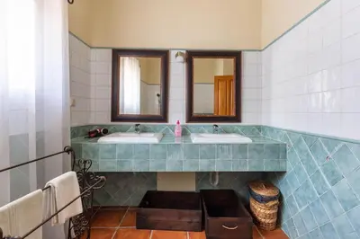a bathroom with two sinks and two mirrors at Monte Velho in Loulé