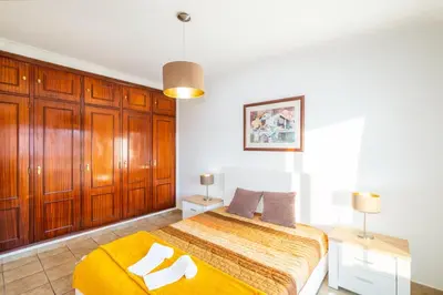 a bedroom with a bed and wooden cabinets at Villa Sequeira - Private Pool - Free WIFI - BY BEDZY in Albufeira