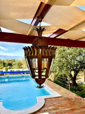 a lamp on a patio next to a swimming pool at Einzigartige Landhaus-Villa mit Pool, Sauna, Bar und BBQ in Boliqueime