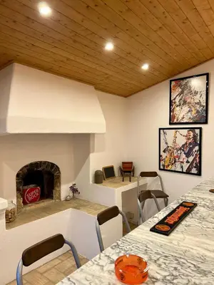 a room with a fireplace and a table and chairs at Einzigartige Landhaus-Villa mit Pool, Sauna, Bar und BBQ in Boliqueime