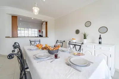 a dining room table with white plates and fruit on it at Villa Lemos by HelloVacations in Albufeira