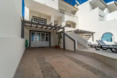 a large white house with a patio and stairs at Villa Lemos by HelloVacations in Albufeira