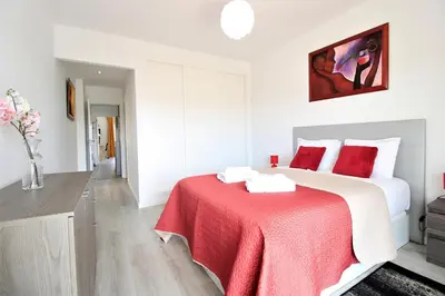 a bedroom with a large bed with a red blanket at Albufeira Prestige With Pool by Homing in Albufeira