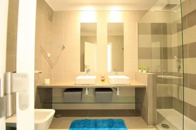 a bathroom with two sinks and a shower at Albufeira Prestige With Pool by Homing in Albufeira