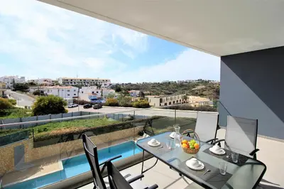 a balcony with a table and chairs and a view at Albufeira Prestige With Pool by Homing in Albufeira