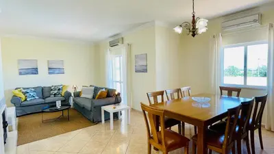 a living room with a table and a dining room at Lara Lima by Check-in Portugal in Albufeira