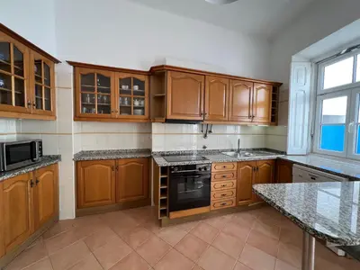 a kitchen with wooden cabinets and a stove top oven at Santa Clara Old Town in Albufeira