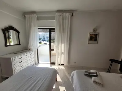 a bedroom with two beds and a dresser and a mirror at Blue Algarve in Albufeira