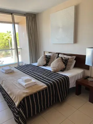 a bedroom with a large bed with a window at Salgados, Vila das Lagoas in Albufeira