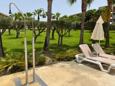 a lounge chair and an umbrella next to a street light at Salgados, Vila das Lagoas in Albufeira