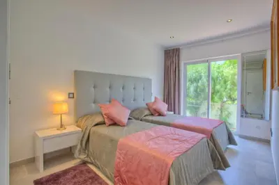 a bedroom with a large bed with pink pillows at Casa da Horta in Almancil