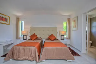 a bedroom with two beds with orange pillows at Casa da Horta in Almancil