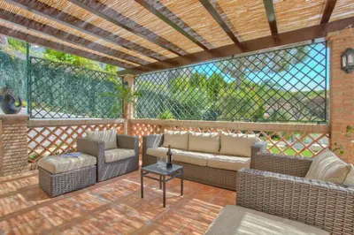 a patio with couches and chairs on a wooden deck at Casa da Horta in Almancil