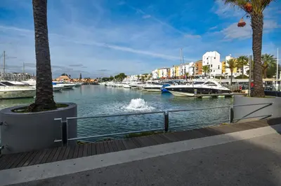 a marina with boats in the water and palm trees at Vila Atlântida - Vilamoura-Quarteira Holiday Home - Beach at 250 mts in Quarteira