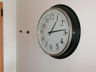 a clock hanging on a wall next to a door at Modern apartment with sunny south facing terrace in Albufeira