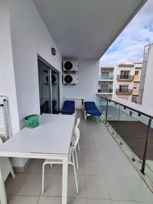 a balcony with a white table and chairs at Modern apartment with sunny south facing terrace in Albufeira