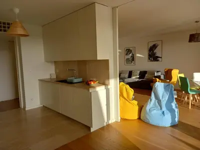 a kitchen and a living room with yellow chairs at Prestige & Nature Apartment in Laguna Village in Quarteira