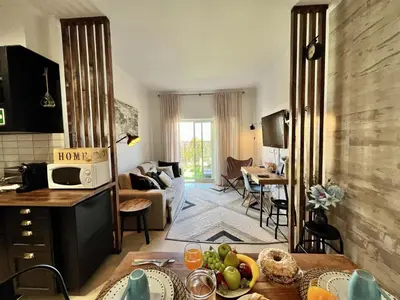 a kitchen and living room with a table and a living room at Albufeira Stylish 1 by Homing in Albufeira