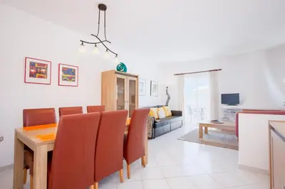 a dining room and living room with a table and chairs at Amazing 2-Bedroom Appartment with big terrace! in Albufeira