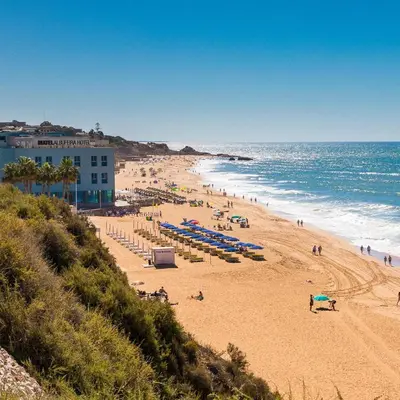 a beach with people and umbrellas and the ocean at Amazing 2-Bedroom Appartment with big terrace! in Albufeira