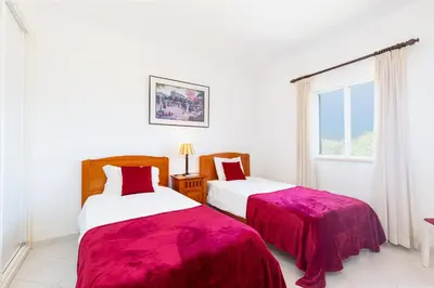two beds in a white room with a window at Amazing 2-Bedroom Appartment with big terrace! in Albufeira