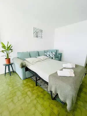 a bedroom with a bed and a couch and a table at Ocean View Apartment Hakuna Matata in Albufeira
