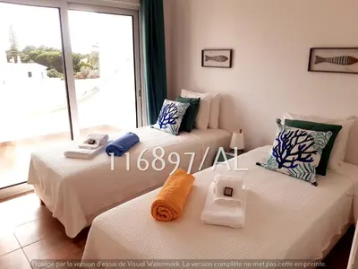 two beds in a room with a large window at Beach Apartment Terrace in Vilamoura