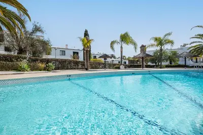 a large swimming pool with palm trees and a building at #082 Families Only - São Rafael by Home Holidays in Albufeira