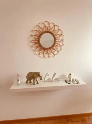 a shelf with a bear figurine and a mirror at OmniaX Apartment in Faro
