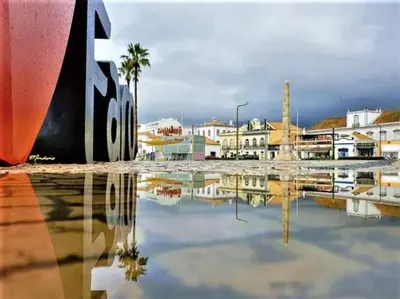 a reflection of a city in a body of water at OmniaX Apartment in Faro
